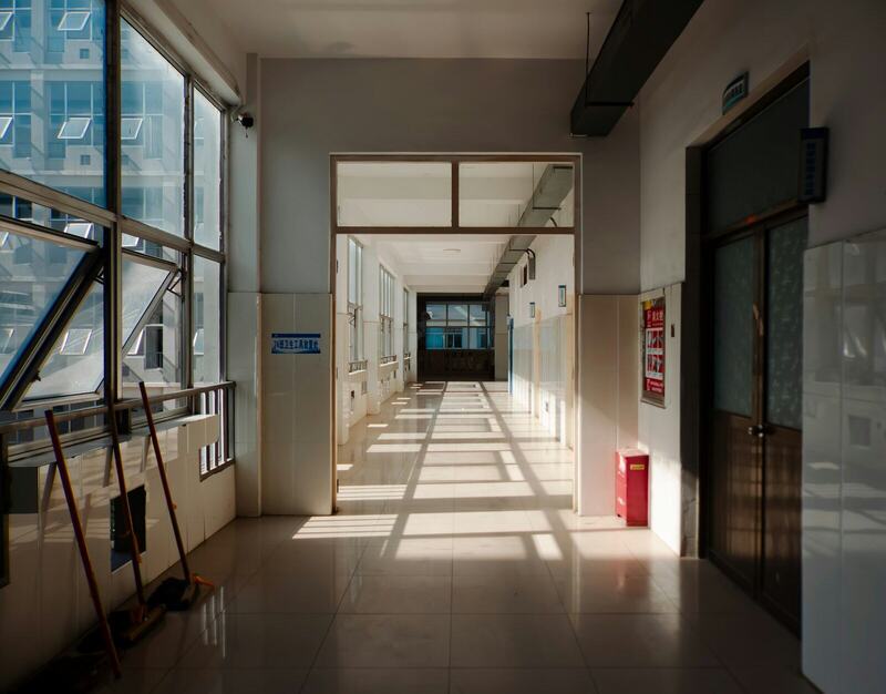 A long, quiet hallway with sunlight falling across the floor